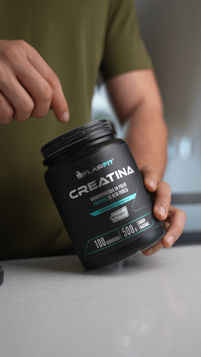 Person holding the FLAIRFIT Creapure creatine 500 g container.